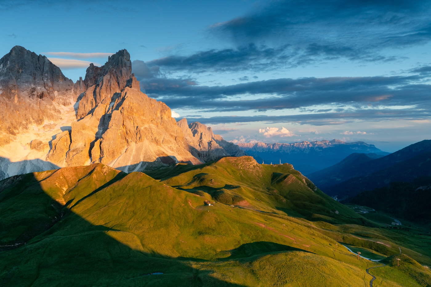 Tramonto sulle Pale di San Martino con i prati del passo in ombra